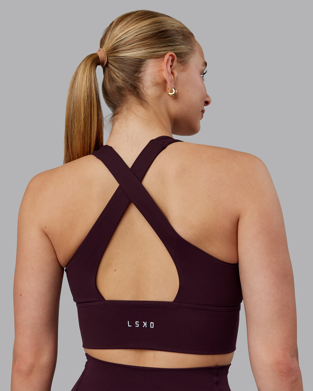 Woman wearing Evoke Sports Bra - Mulberry - view 1