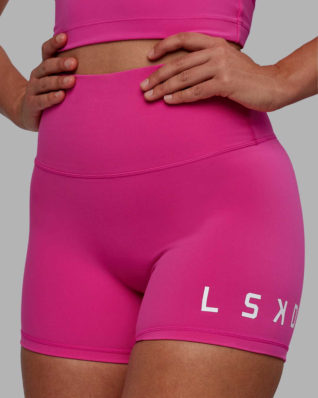 Woman wearing Evolved Ultra High-Rise 4" Short - Fuchsia Pink-White - view 1