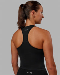 Woman wearing Flow Shelf Bra Performance Tank - Black | Thumbnail Index: 1