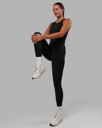 Woman wearing Flow Shelf Bra Performance Tank - Black | Thumbnail Index: 3