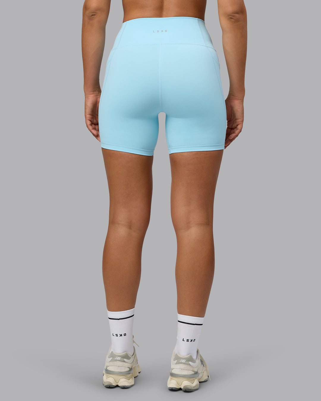 Woman wearing Fusion Ultra High-Rise 6" Short Pockets - Crystal Blue | Set:true | Angle:back | Model:Sophie | Size:S - view 3