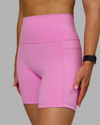 Woman wearing Fusion Ultra High-Rise 6" Short Pockets - Spark Pink | Model:Halle | Size:S | Thumbnail Index: 1
