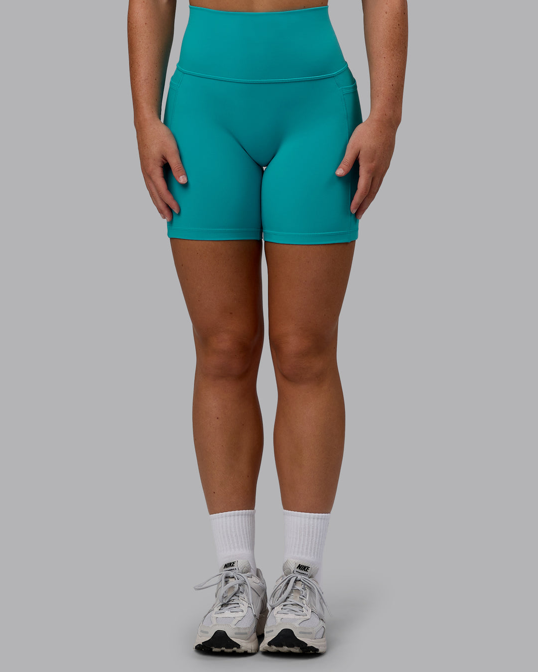 Woman wearing Fusion Ultra High-Rise 6" Short Pockets - Uplift Blue | Set:true | Angle:front | Model:Monique | Size:S - view 9