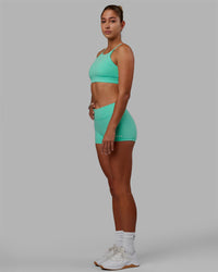 Woman wearing Lift High Neck Sports Bra - Cockatoo | Thumbnail Index: 4