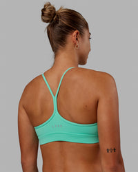 Woman wearing Lift High Neck Sports Bra - Cockatoo | Thumbnail Index: 0