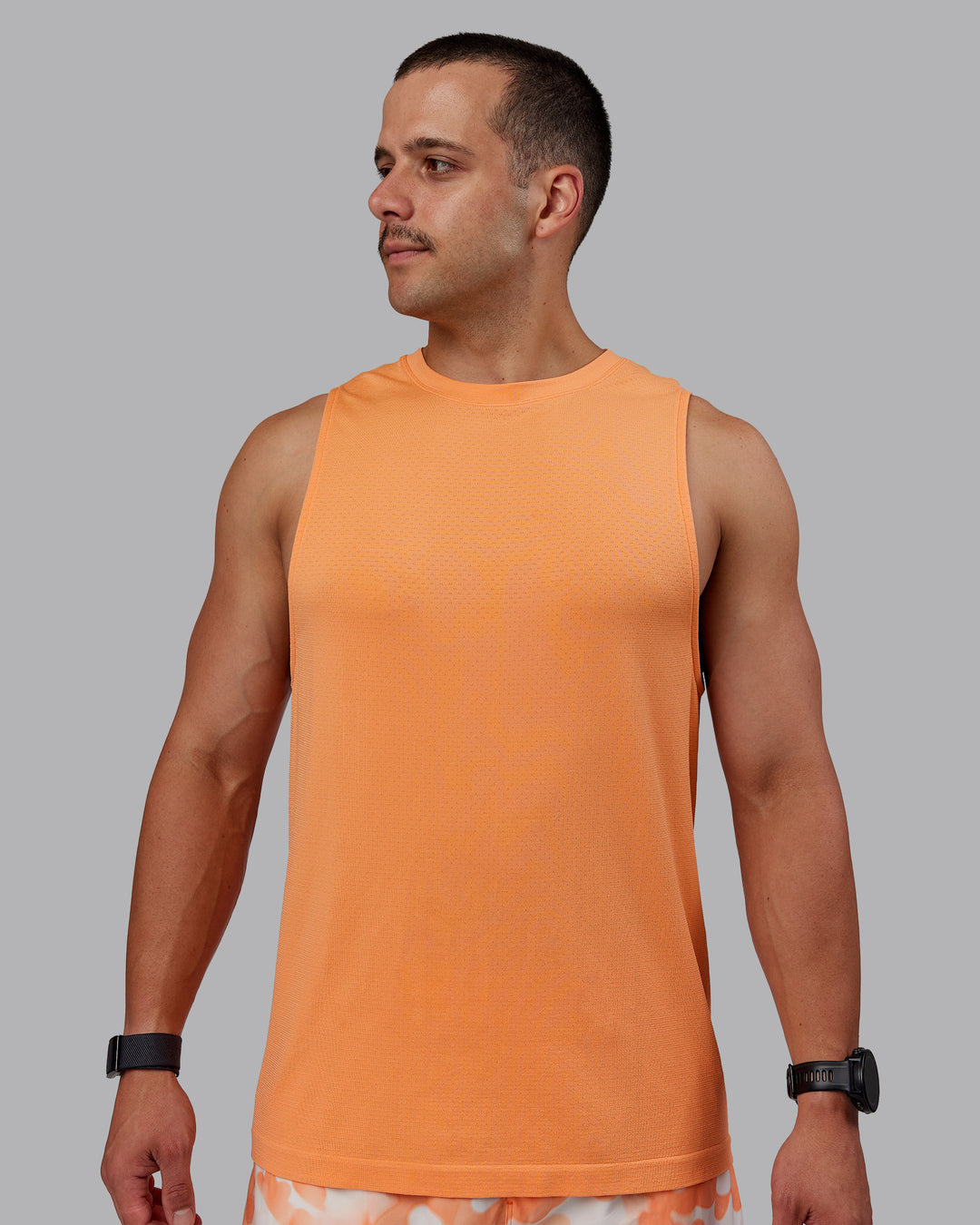 Man wearing AeroFLX+ Seamless Muscle Tank - Cantaloupe/Cantaloupe Marl - view 2