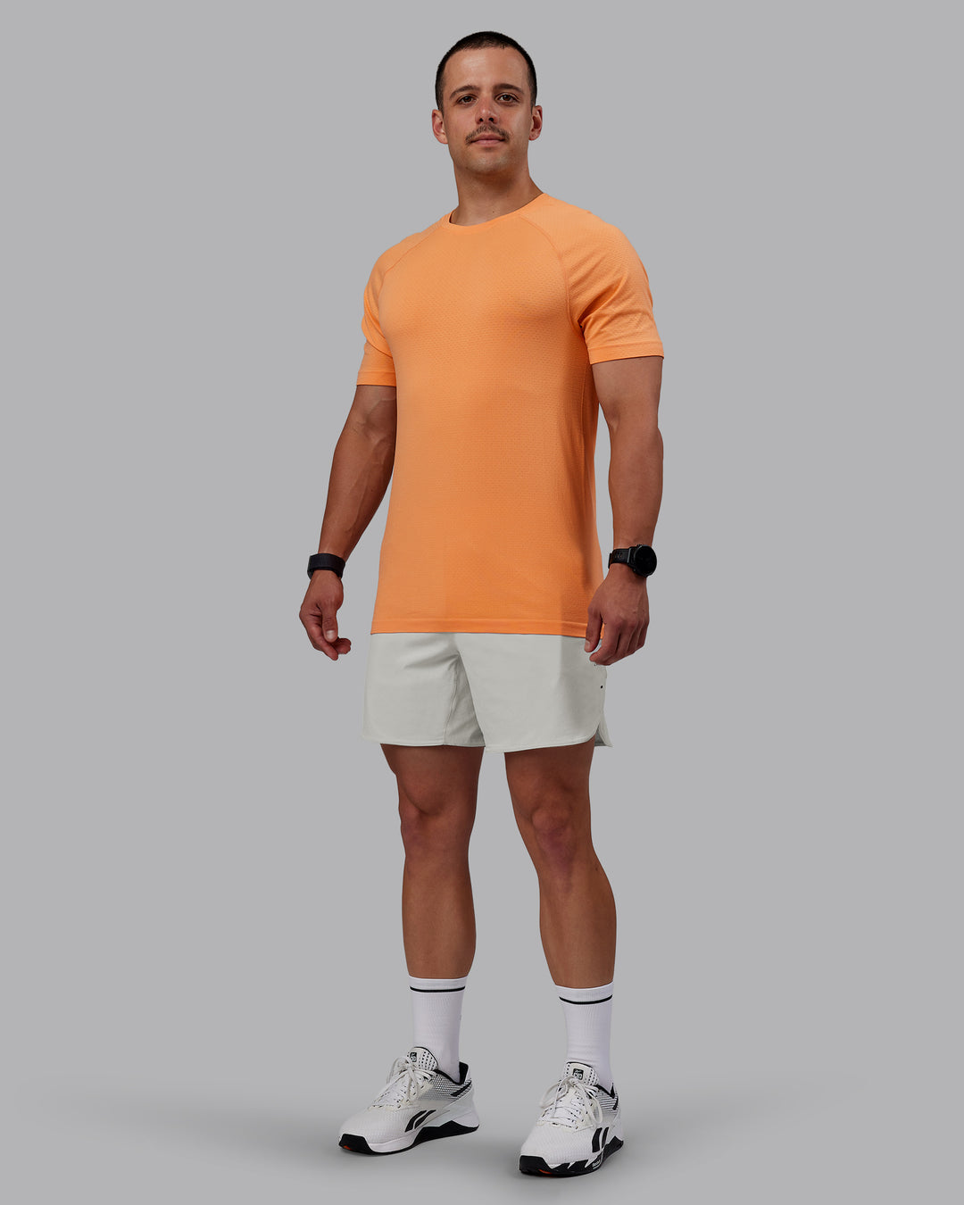 Man wearing AeroFLX+ Seamless Tee - Cantaloupe/Cantaloupe Marl - view 2