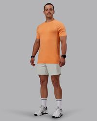 Man wearing AeroFLX+ Seamless Tee - Cantaloupe/Cantaloupe Marl | Thumbnail Index: 1