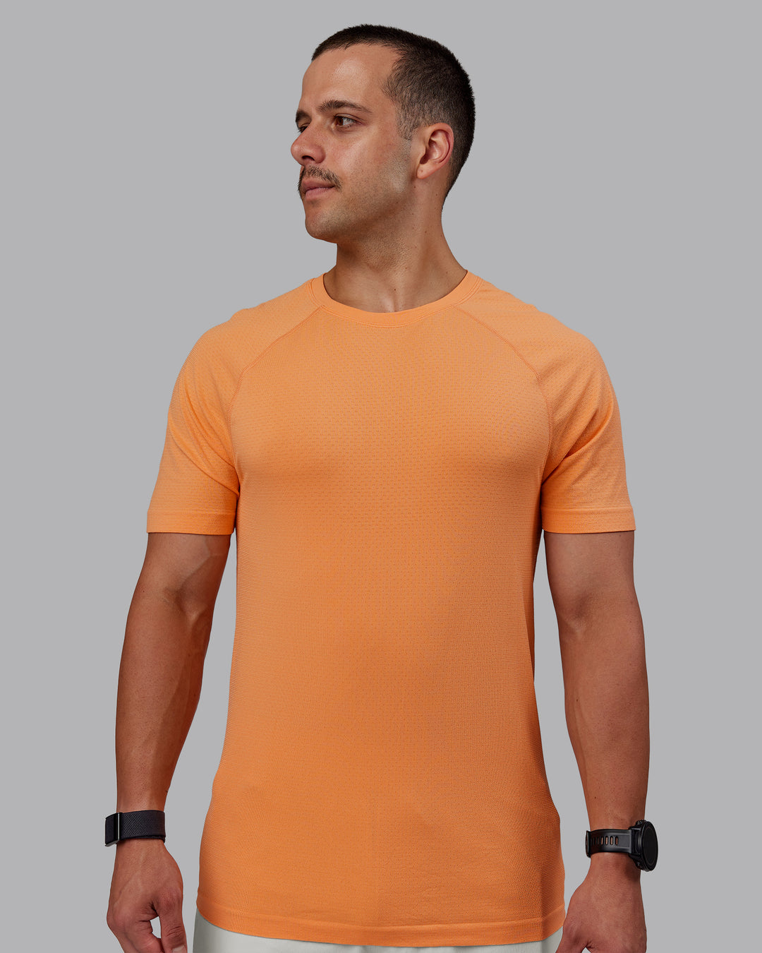 Man wearing AeroFLX+ Seamless Tee - Cantaloupe/Cantaloupe Marl - view 1