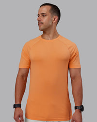 Man wearing AeroFLX+ Seamless Tee - Cantaloupe/Cantaloupe Marl | Thumbnail Index: 0