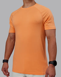 Man wearing AeroFLX+ Seamless Tee - Cantaloupe/Cantaloupe Marl | Thumbnail Index: 2