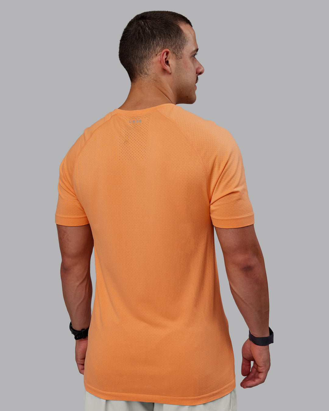Man wearing AeroFLX+ Seamless Tee - Cantaloupe/Cantaloupe Marl - view 4