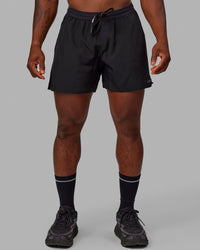 Man wearing Pace 5" Lined Performance Shorts - Black-Reflective | Thumbnail Index: 0