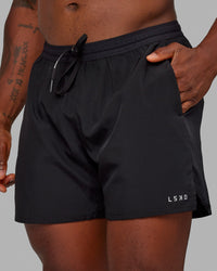 Man wearing Pace 5" Lined Performance Shorts - Black-Reflective | Thumbnail Index: 1