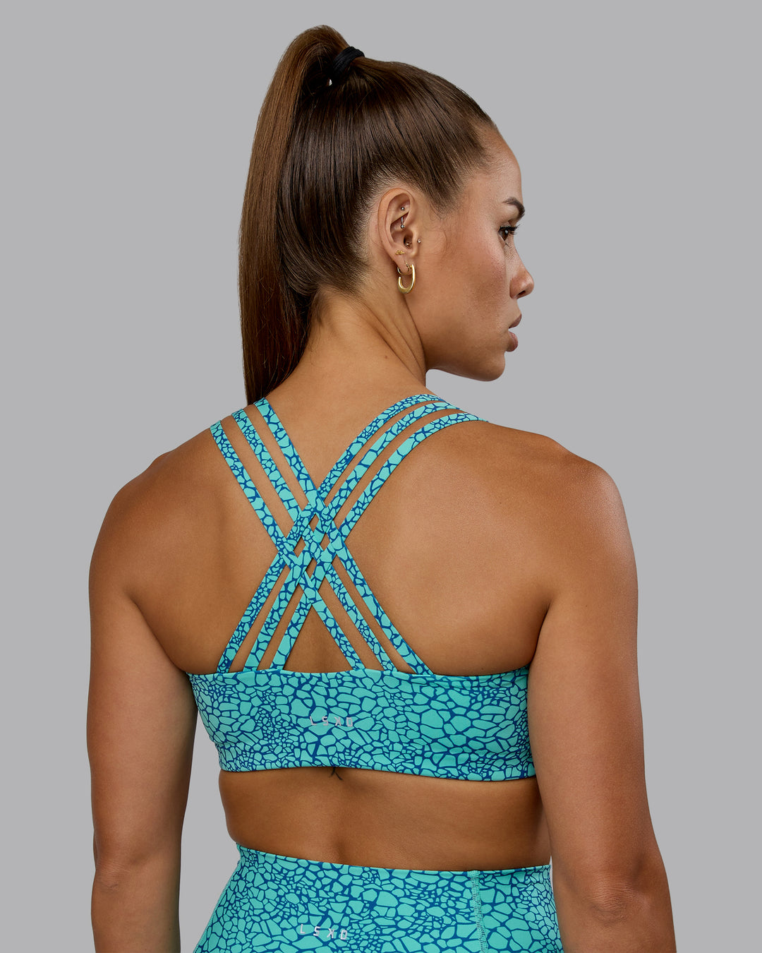Woman wearing Push The Limit Sports Bra - Aquatic Awe Vitality Print - view 1