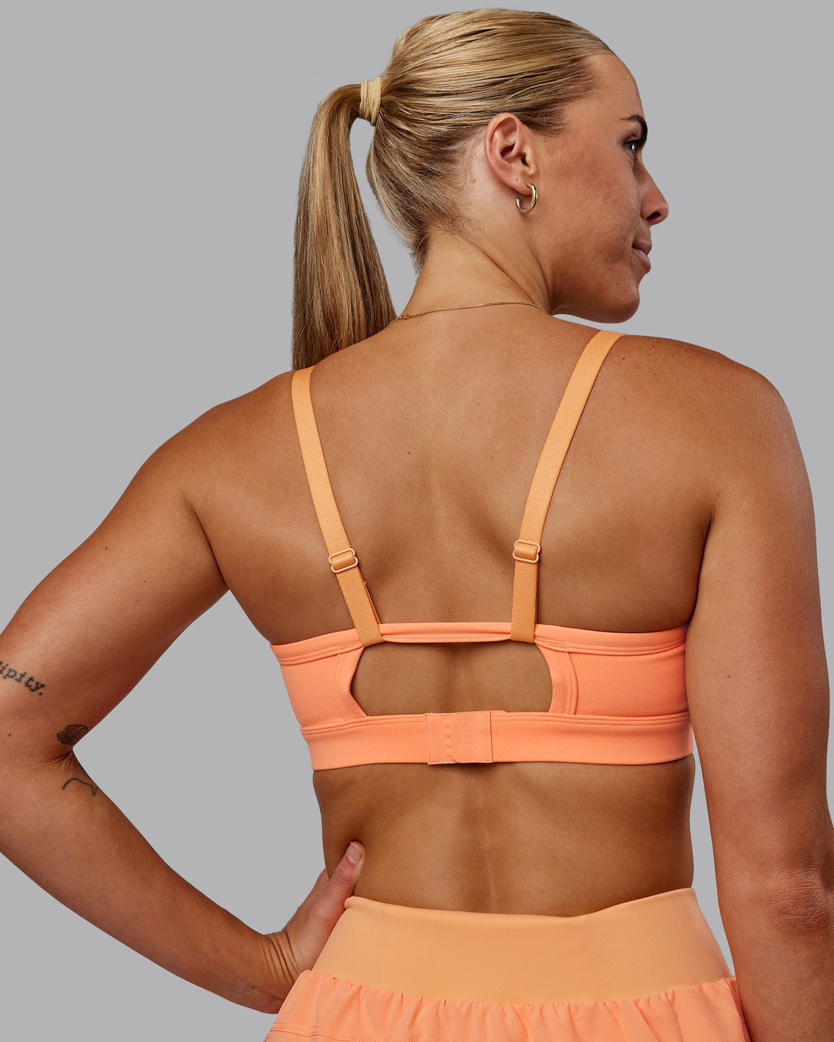 Woman wearing Rapid Sports Bra - Cantaloupe