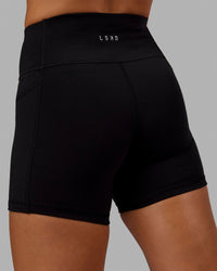 Woman wearing O.G. Rep Ultra High-Rise 4" Short Pockets - Black-Black | Model:Abbey| Size:S | Thumbnail Index: 2