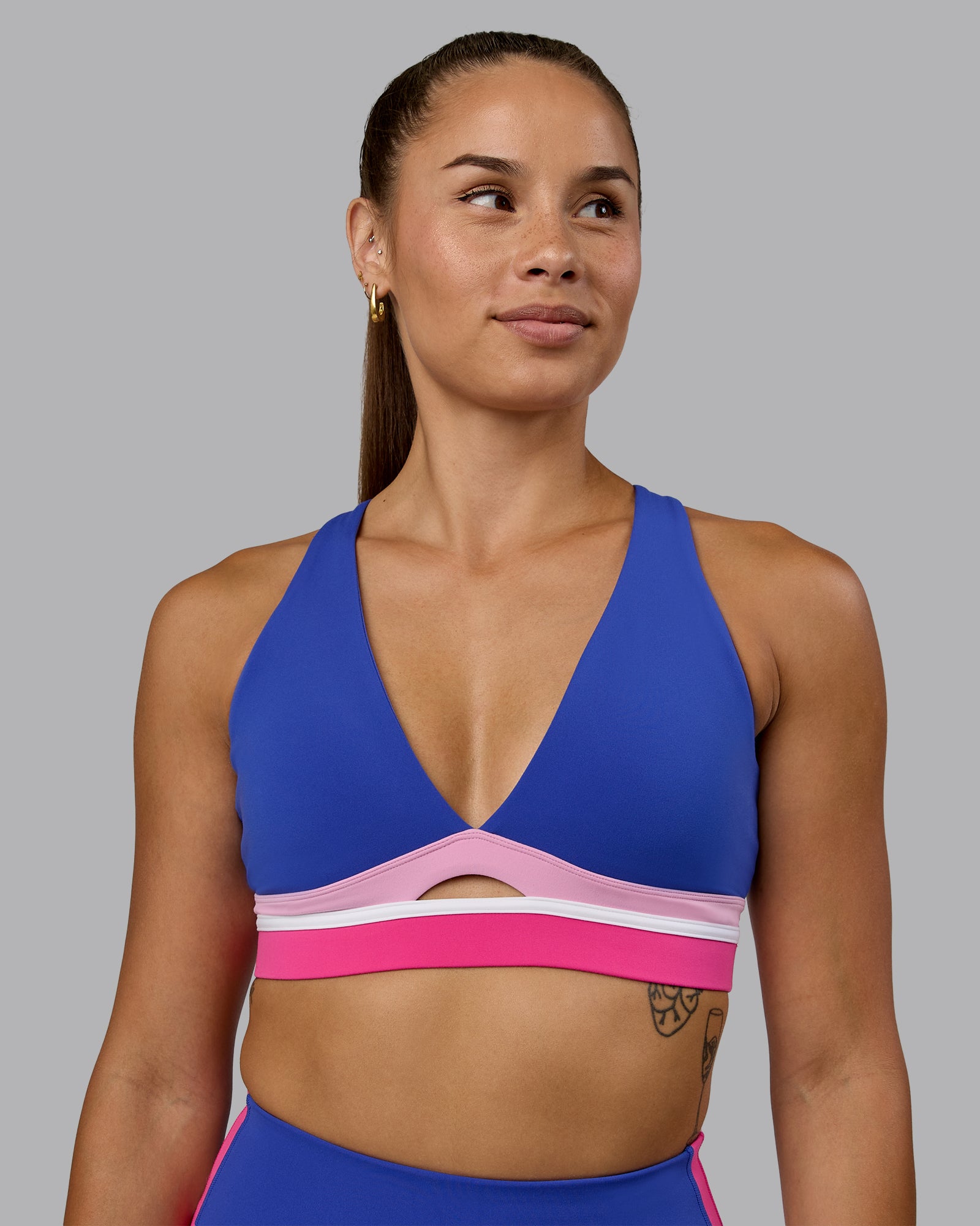 Woman wearing Revitalise Sports Bra - Power Cobalt-Fuchsia Pink