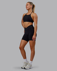 Woman wearing Sara Strike Ultra High-Rise Cross Over Waist 6" Short - Black | Thumbnail Index: 4