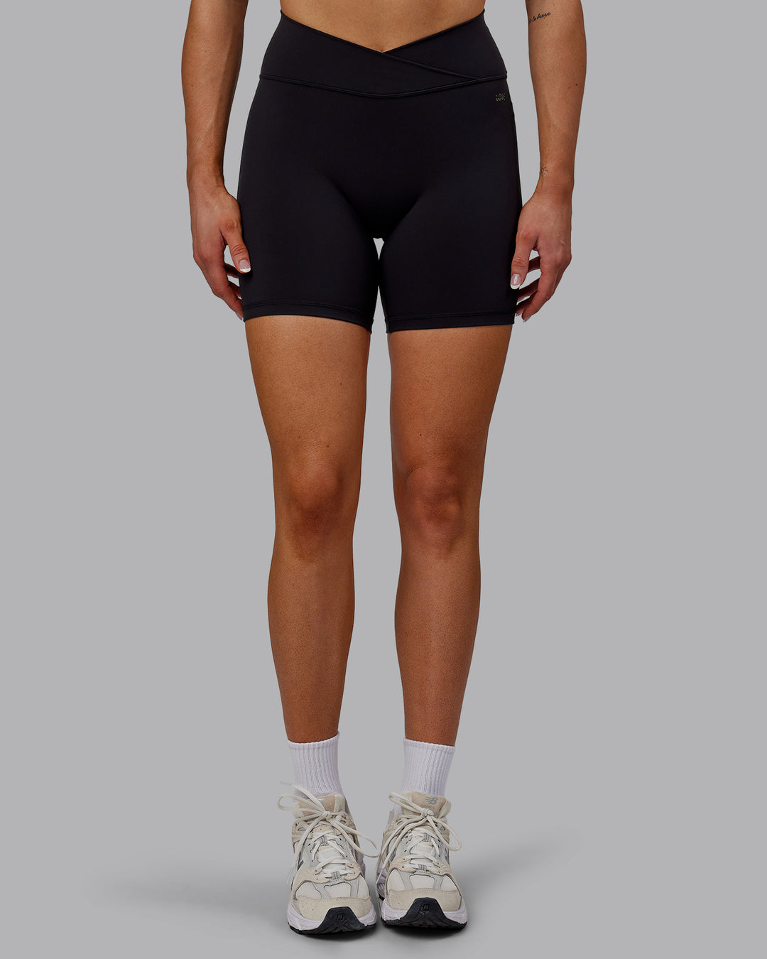 Woman wearing Sara Strike Ultra High-Rise Cross Over Waist 6" Short - Black - view 3