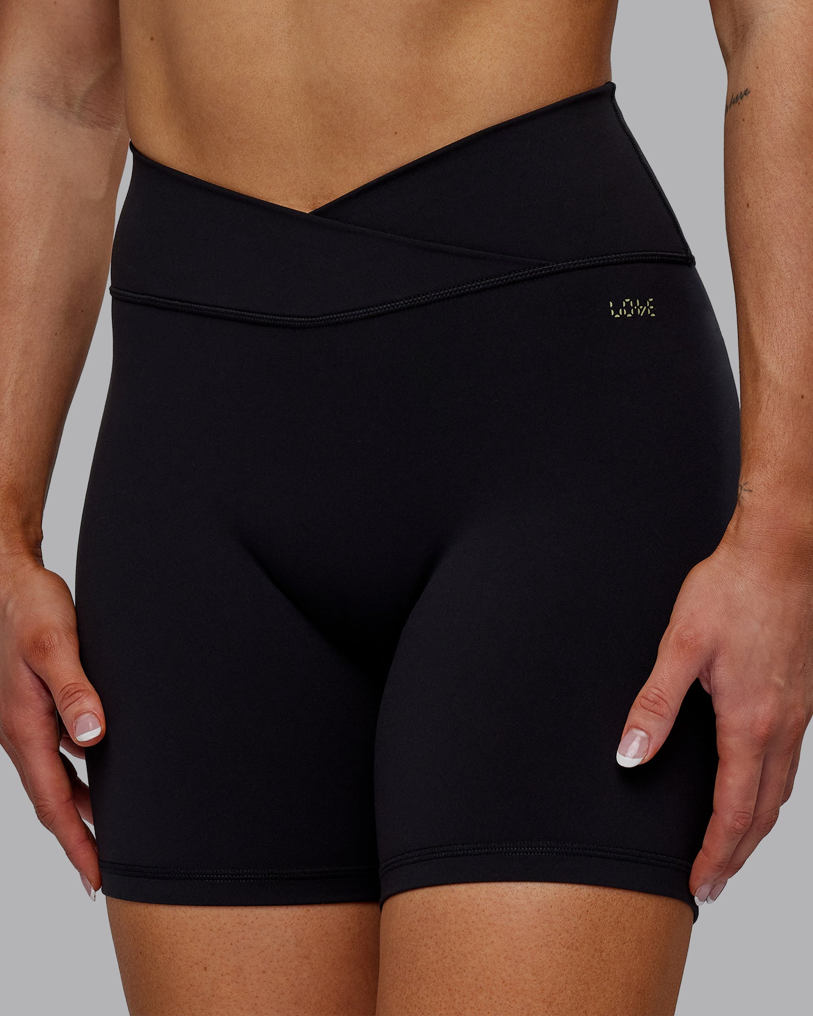 Woman wearing Sara Strike Ultra High-Rise Cross Over Waist 6" Short - Black