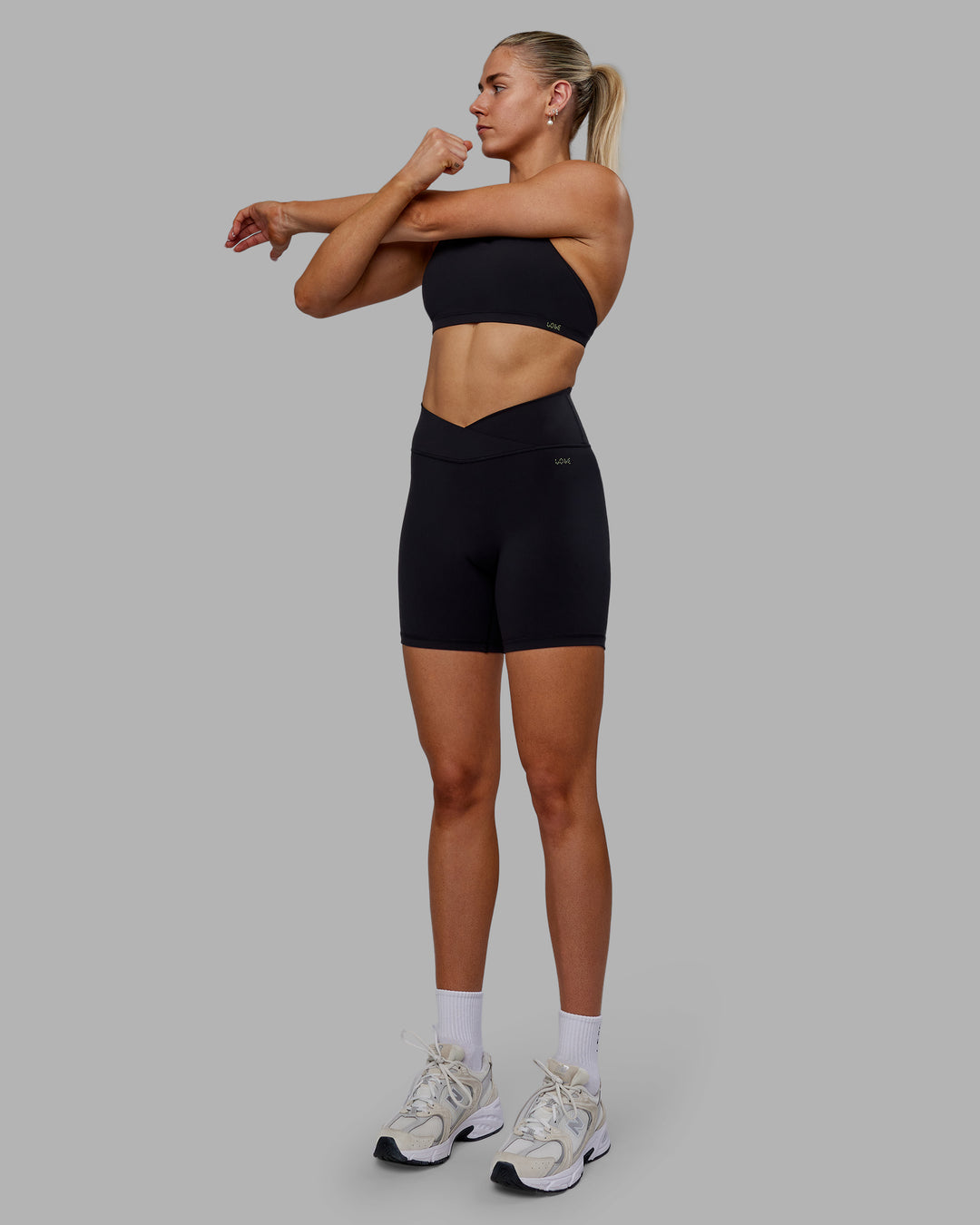 Woman wearing Sara Strike Ultra High-Rise Cross Over Waist 6" Short - Black - view 6