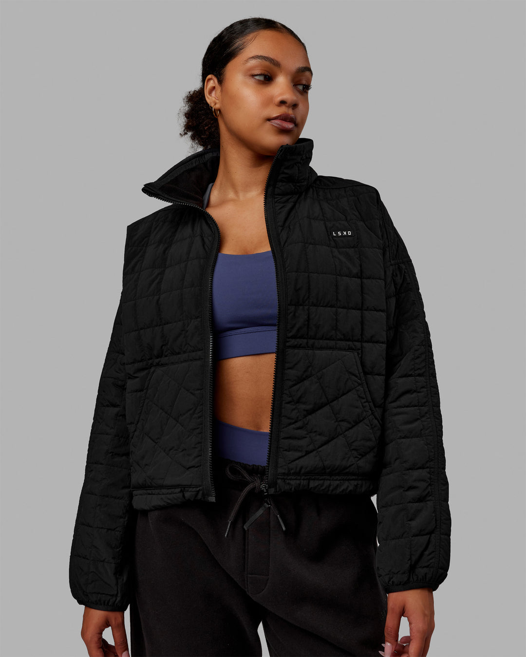 Woman wearing Thrive Packable Jacket - Black - view 1