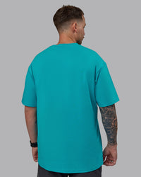 Man wearing Unisex 1% Better FLXCotton Tee Oversize - Blue Bird-White | Thumbnail Index: 3