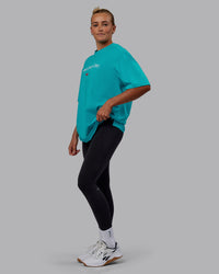 Woman wearing Unisex 1% Better FLXCotton Tee Oversize - Blue Bird-White | Thumbnail Index: 6