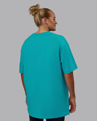 Woman wearing Unisex 1% Better FLXCotton Tee Oversize - Blue Bird-White | Thumbnail Index: 9