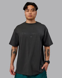 Man wearing Unisex 1% Better FLXCotton Tee Oversize - Pirate Black-Black | Thumbnail Index: 6