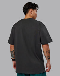 Man wearing Unisex 1% Better FLXCotton Tee Oversize - Pirate Black-Black | Thumbnail Index: 3