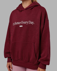 Woman wearing Unisex 1% Better Hoodie Oversize - Cranberry-White | Thumbnail Index: 6