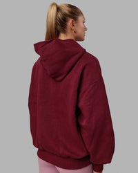 Woman wearing Unisex 1% Better Hoodie Oversize - Cranberry-White | Thumbnail Index: 10