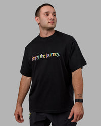 Man wearing Unisex Enjoy The Journey Heavyweight Tee Oversize - Black-Multi | Thumbnail Index: 1