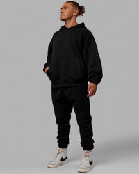 Man wearing Unisex MVP Hoodie Oversize - Black | Thumbnail Index: 8
