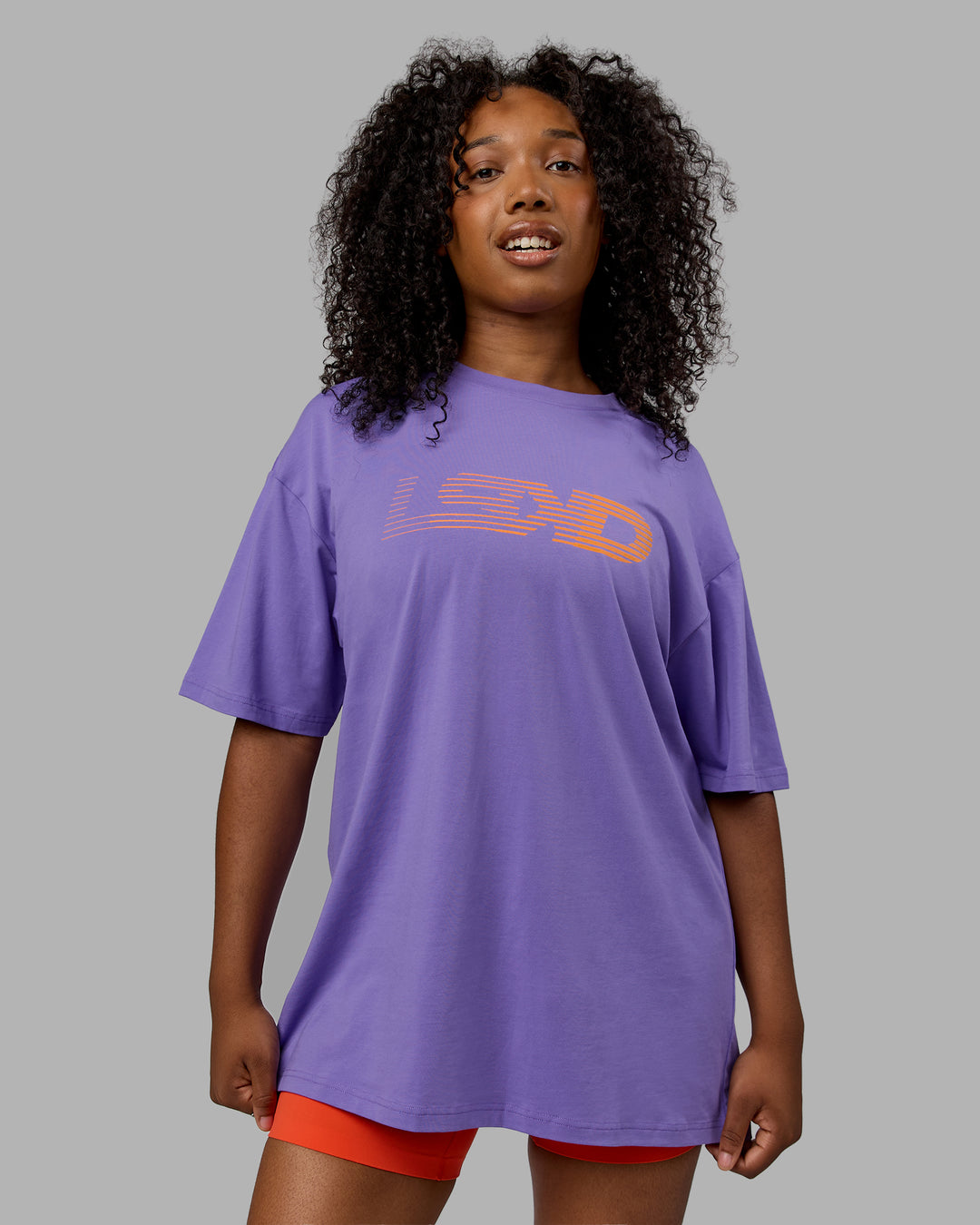 Woman wearing Unisex Motion FLXCotton Tee Oversize - Dahlia Purple-Vibrant Orange - view 2