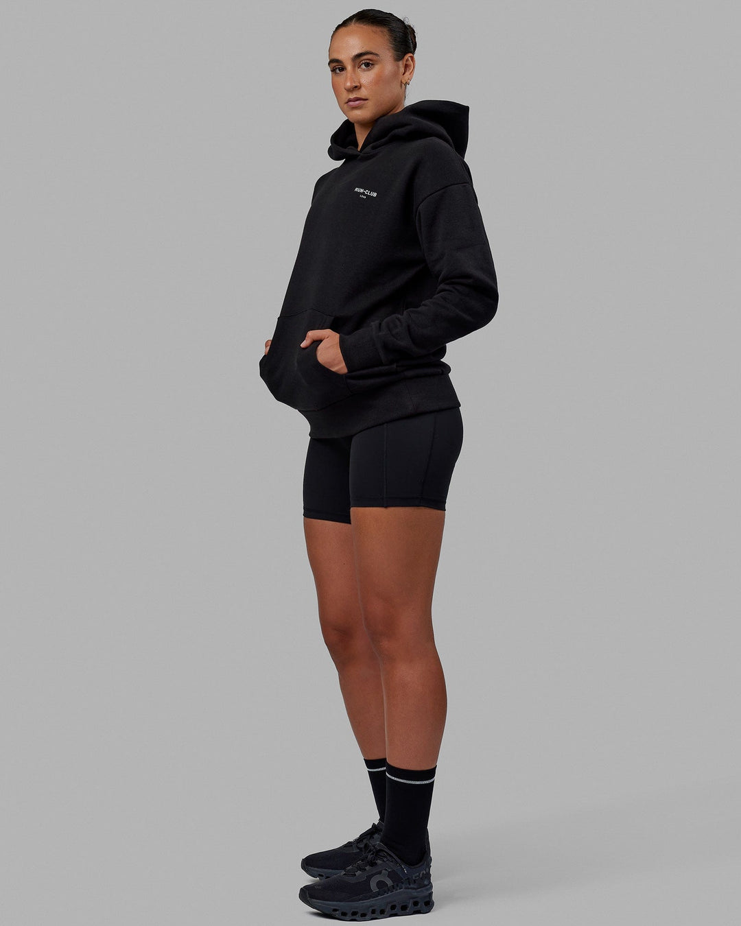 Woman wearing Unisex RUN-CLUB Hoodie Oversize - Black - view 3