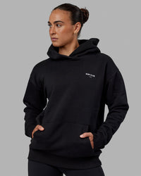 Woman wearing Unisex RUN-CLUB Hoodie Oversize - Black | Thumbnail Index: 5