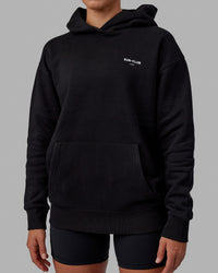 Woman wearing Unisex RUN-CLUB Hoodie Oversize - Black | Thumbnail Index: 8