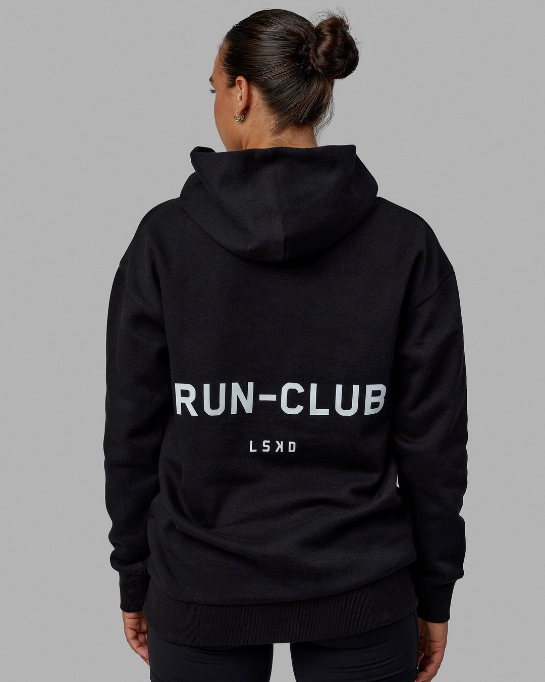 Woman wearing Unisex RUN-CLUB Hoodie Oversize - Black - view 4