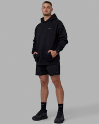 Man wearing Unisex RUN-CLUB Hoodie Oversize - Black | Thumbnail Index: 11