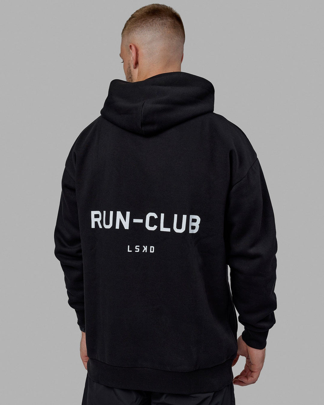 Man wearing Unisex RUN-CLUB Hoodie Oversize - Black - view 8