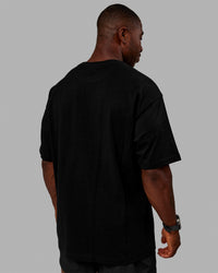 Man wearing Unisex Stamped 2.0 Heavyweight Tee Oversize - Black | Thumbnail Index: 4