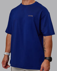 Man wearing Unisex Strike Through FLXCotton Tee Oversize - Midnight Blue-Vibrant Orange | Thumbnail Index: 8