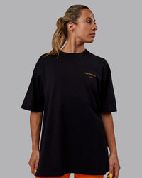 Woman wearing Unisex Trust The Process 2.0 FLXCotton Tee Oversize - Black-Vibrant Orange | Thumbnail Index: 3