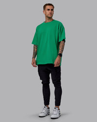 Man wearing Unisex We Rise Heavyweight Tee Oversize - Impact Green-White | Thumbnail Index: 6