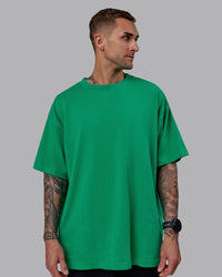 Man wearing Unisex We Rise Heavyweight Tee Oversize - Impact Green-White | Thumbnail Index: 4