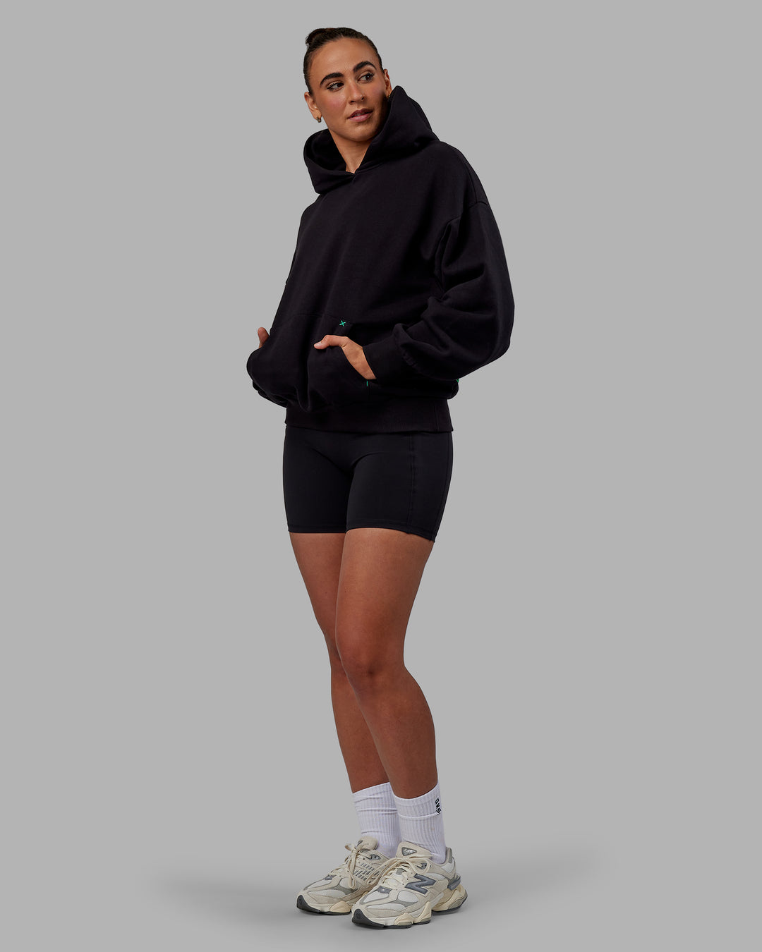 Woman wearing Unisex We Rise Hoodie Oversize - Black-Impact Green - view 6