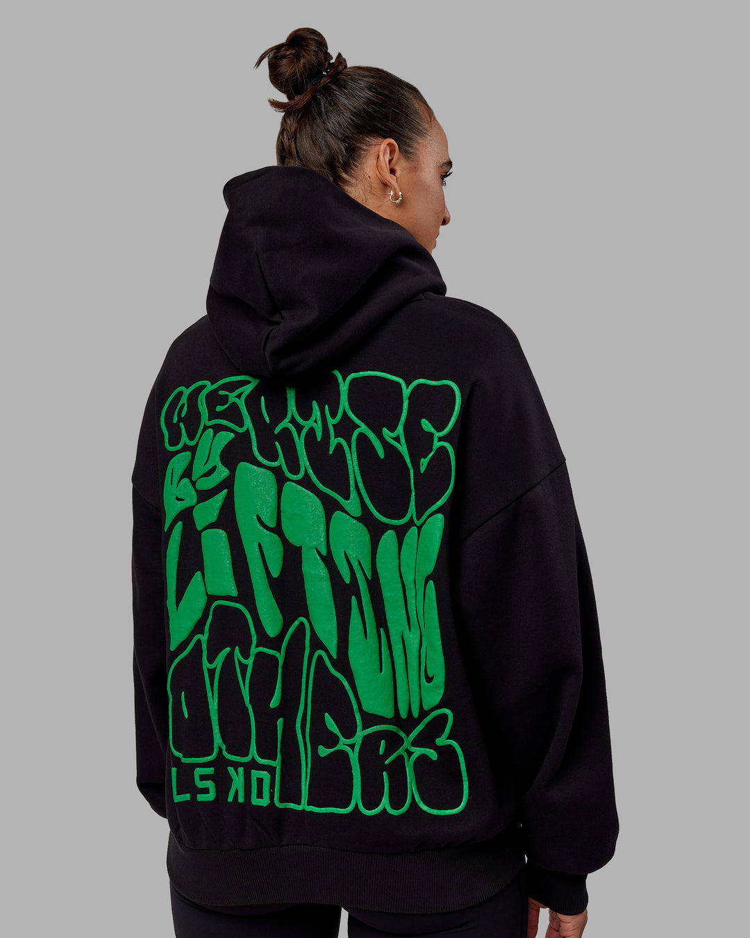 Woman wearing Unisex We Rise Hoodie Oversize - Black-Impact Green - view 4